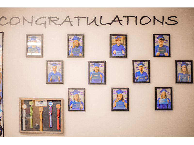 Students images on a wall that says congratulations