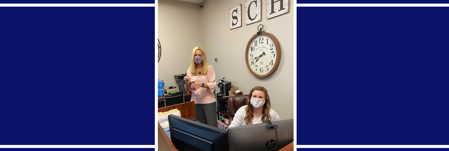 Two staff members near a clock