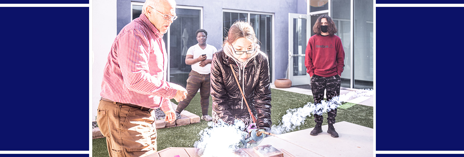 Students and staff performing science experiment outside