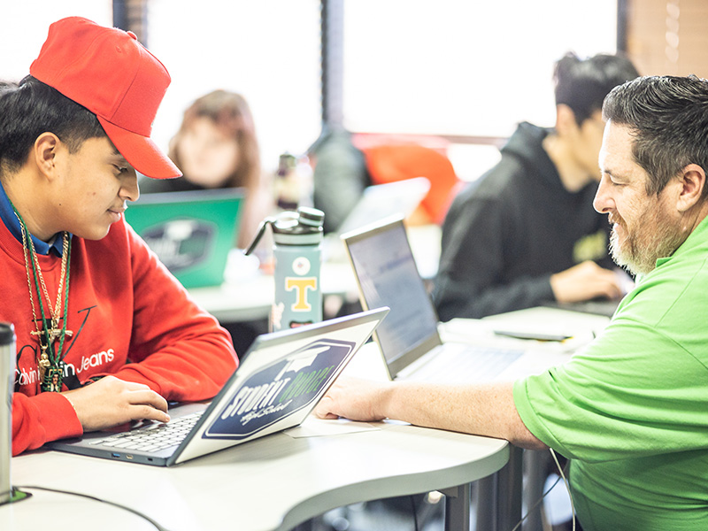 students working on laptops at desks