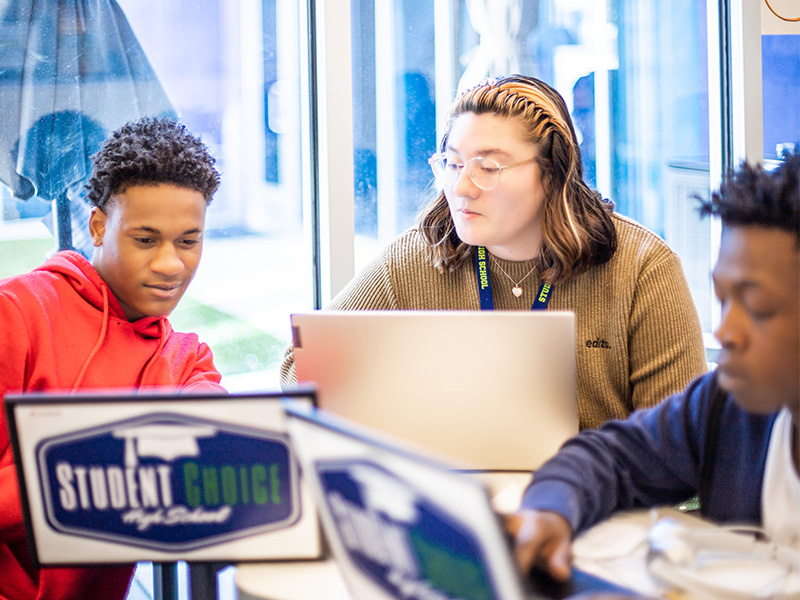 Three students working on laptops