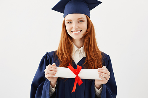 Happy female graduate in cap smiling looking at camera holding diploma
